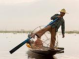 Traditional fisherman on Inle Lake  The fishermen beat the water with their oars to stun the fish, then lower their conical nets to capture them.  They poke tridents into the end to catch the fish.