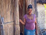 Woman and child with thatched house  Okavanga River Delta, Botswana